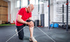 Man taking a knee in the gym showing signs of inflammation