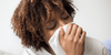Woman blowing her nose and looking for ways to boost immune system after a cold