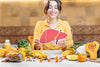 Woman sitting in front of a table with healthy foods and a fatty liver graphic
