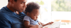 Dad sitting with his child and reading a book