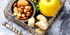 Nuts, apples, and ginger in a basket which are some of the top anti-aging foods to add to your diet