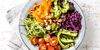 Bowl of broccoli, carrots, tomatoes, zucchini, which are all foods good for healthy hair