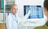 Doctor pointing at brain scans and explaining to a patient how Alzheimer's affects the body's systems