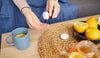 woman taking supplements and drinking lemon tea to boost immunity