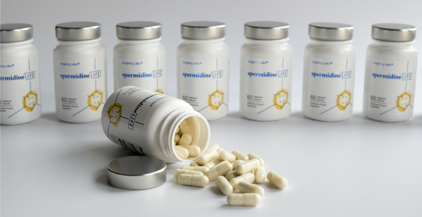 A group of white pills promoting cellular health and autophagy sitting on a white surface.