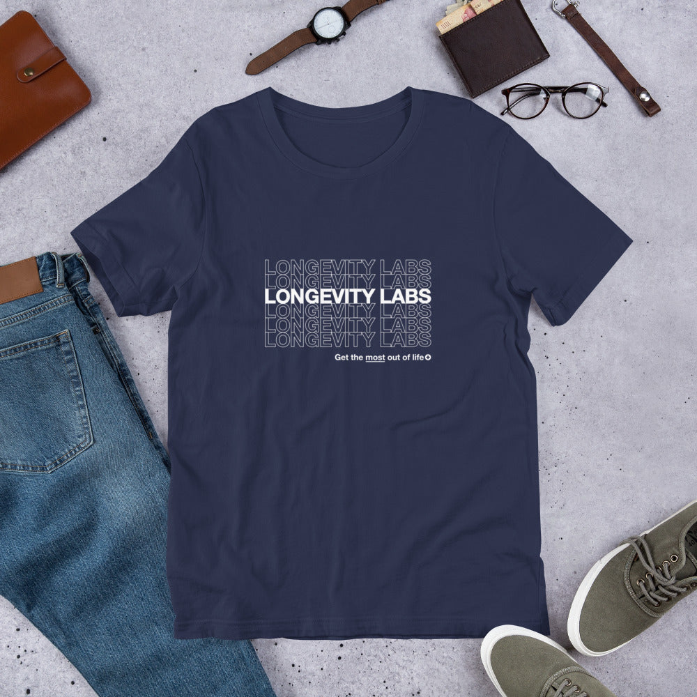 A navy blue, soft Longevity Labs "Classic" Tee (New) with the text "LONGEVITY LABS" printed repeatedly, along with the phrase "Get the most out of life." Made from pre-shrunk cotton by spermidineLIFE® by Longevity Labs, Inc., the shirt is laid out flat on a grey surface, surrounded by various accessories.