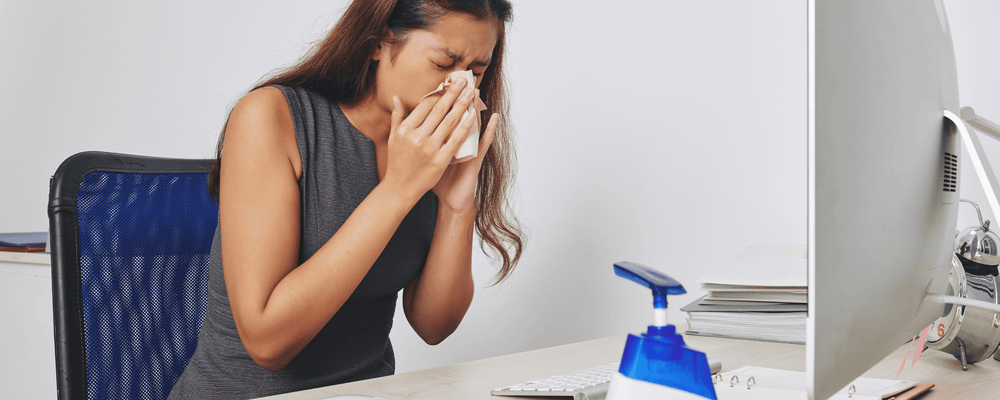 Woman struggling with allergies and blowing her nose