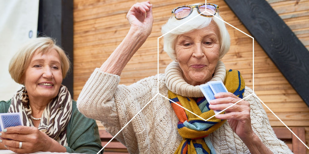 Two elderly women playing cards and in great health