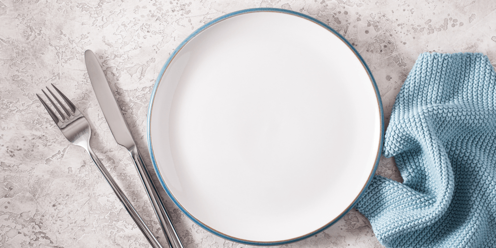 Empty plate with fork and knife to represent fasting