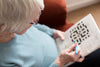 Older woman solving crossword puzzle