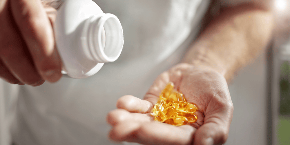 Man dumping one of The Top 5 Vitamins To Boost Immunity into his hands