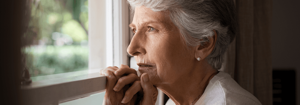 Woman looking out the window who suffers from dementia