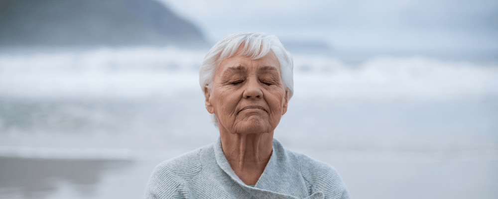 Woman clearing her mind at the ocean relieving anxiety and boosting heart health