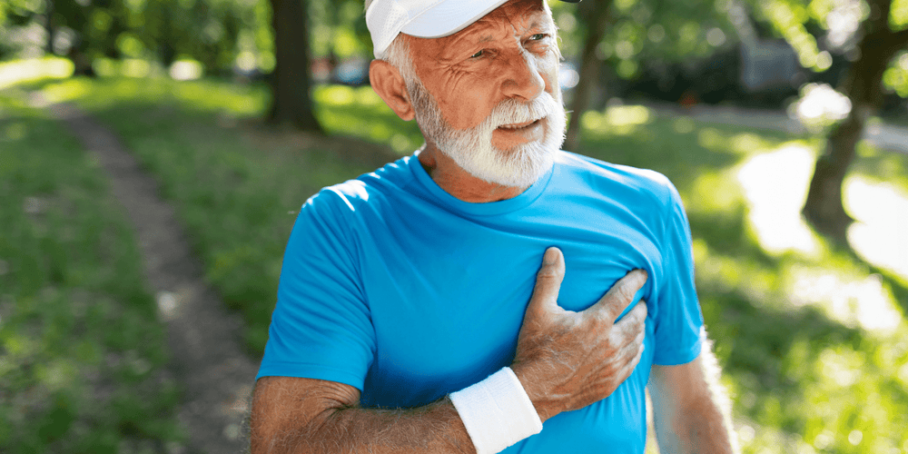 Man gripping his chest with signs of a heart attack