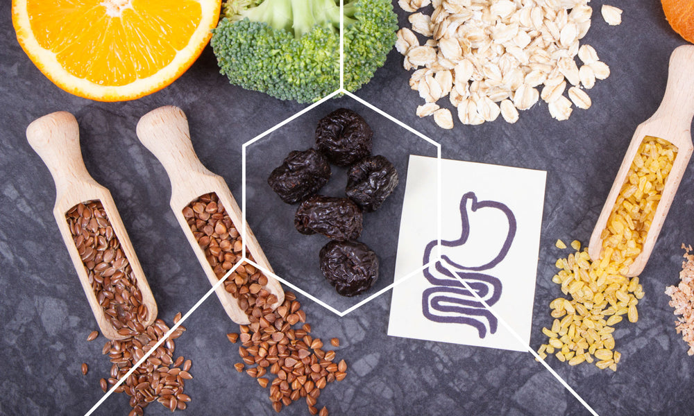 Table with broccoli, oranges, grains, and a drawing of a stomach to represent gut health