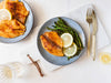 Fish, lemons, and asparagus on a plate which are foods you eat on a longevity diet