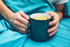 Man holding a mug of tea with lemon trying boost immunity while he's sick