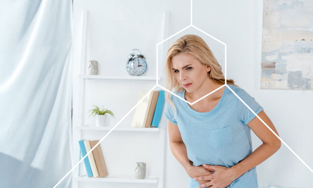 Woman holding her stomach and exhibiting signs of an unhealth gut