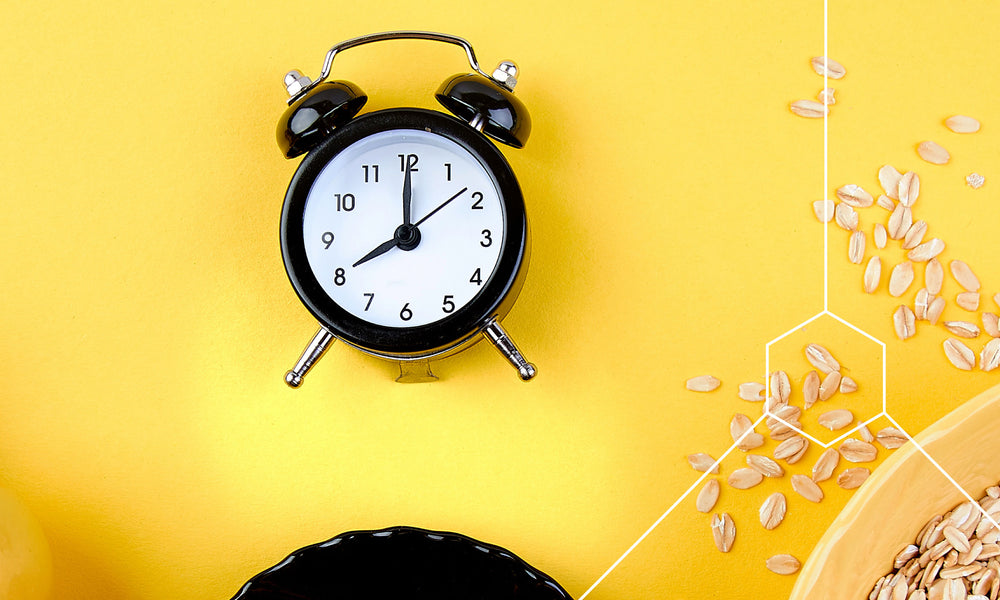 Clock on a table with scattered grains depicting what to eat during intermittent fasting