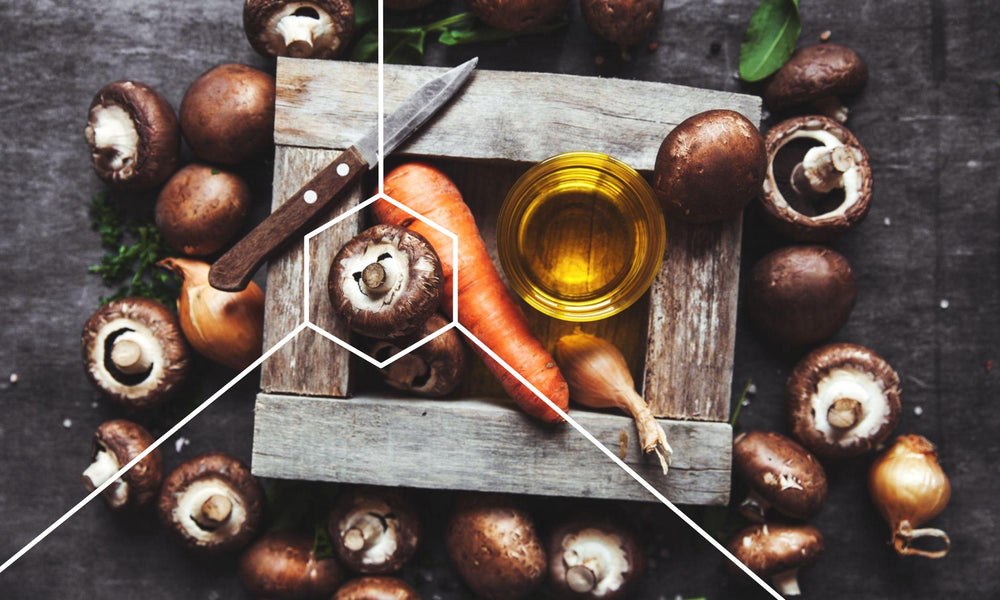 Carrots, oil, and mushrooms on a cutting board which are foods that are high in polyamines